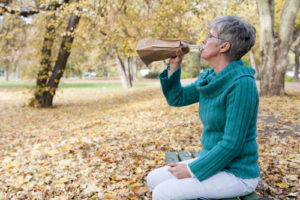 woman drinking alone in park