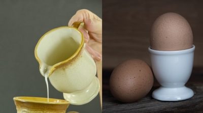 A senior woman's hand poring cream into a coffe cup. Black background.