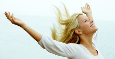 Photo of happy young woman with stretched arms enjoying life