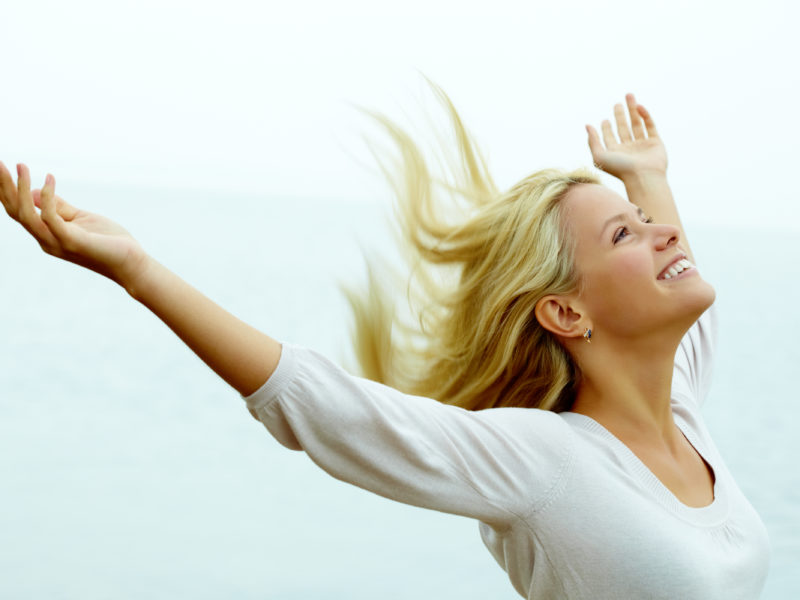Photo of happy young woman with stretched arms enjoying life