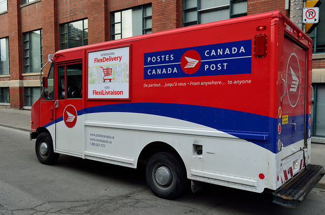 A Canada Post mail truck on a city street