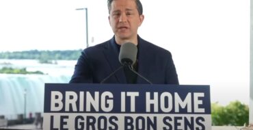 Pierre Poilievre standing at a lectern behind a sign that says "Bring It Home/Le Gros Bon Sens"