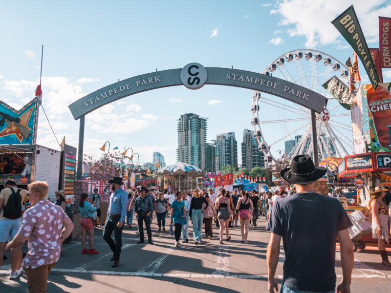 Crowds of people enter Stampede Park, the midway carnival rides and games area
