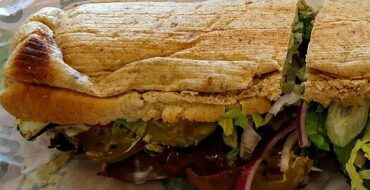 a subway sandwich from subway, on a subway wrapper. looks a little smushed.