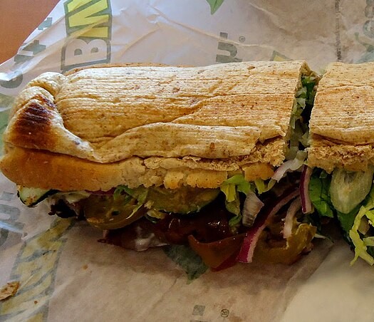 a subway sandwich from subway, on a subway wrapper. looks a little smushed.